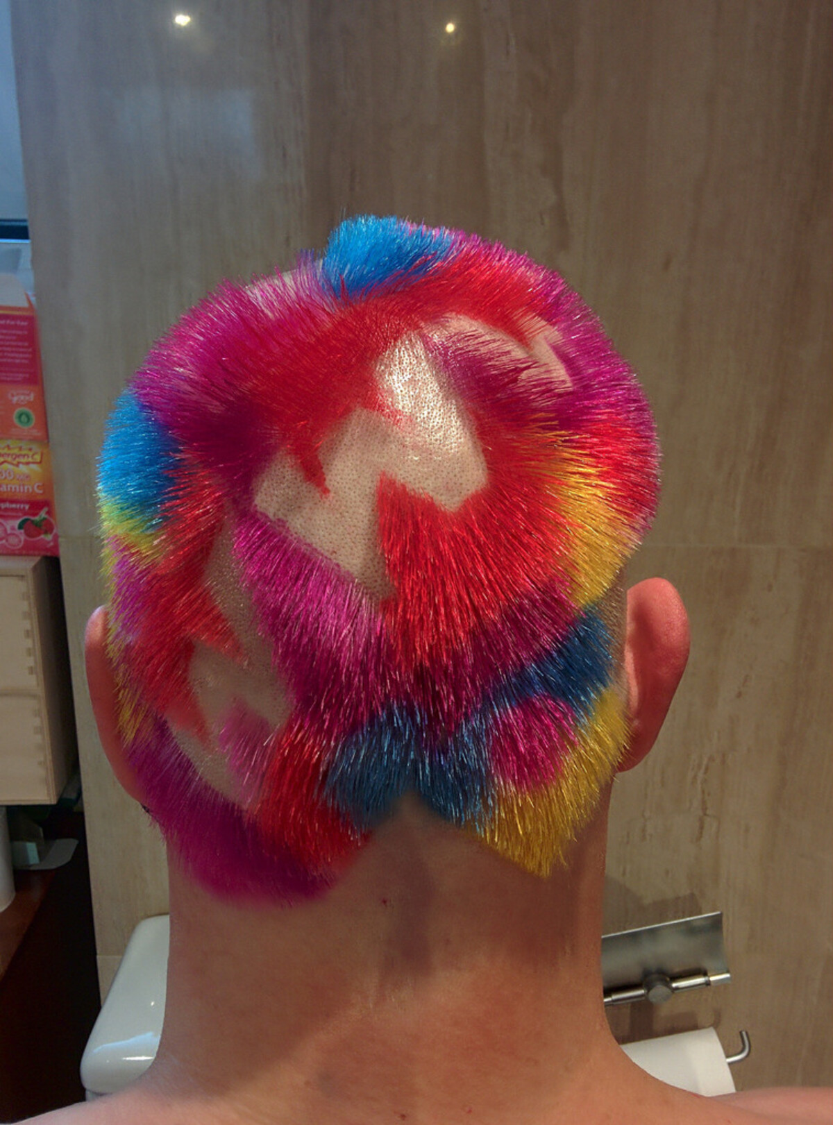 Back of Rob's head, slightly different angle, showing the same multicolor hair with 'WWW' letters shaved into the scalp through blocks of hot pink, blue, magenta, red, and yellow-gold.
