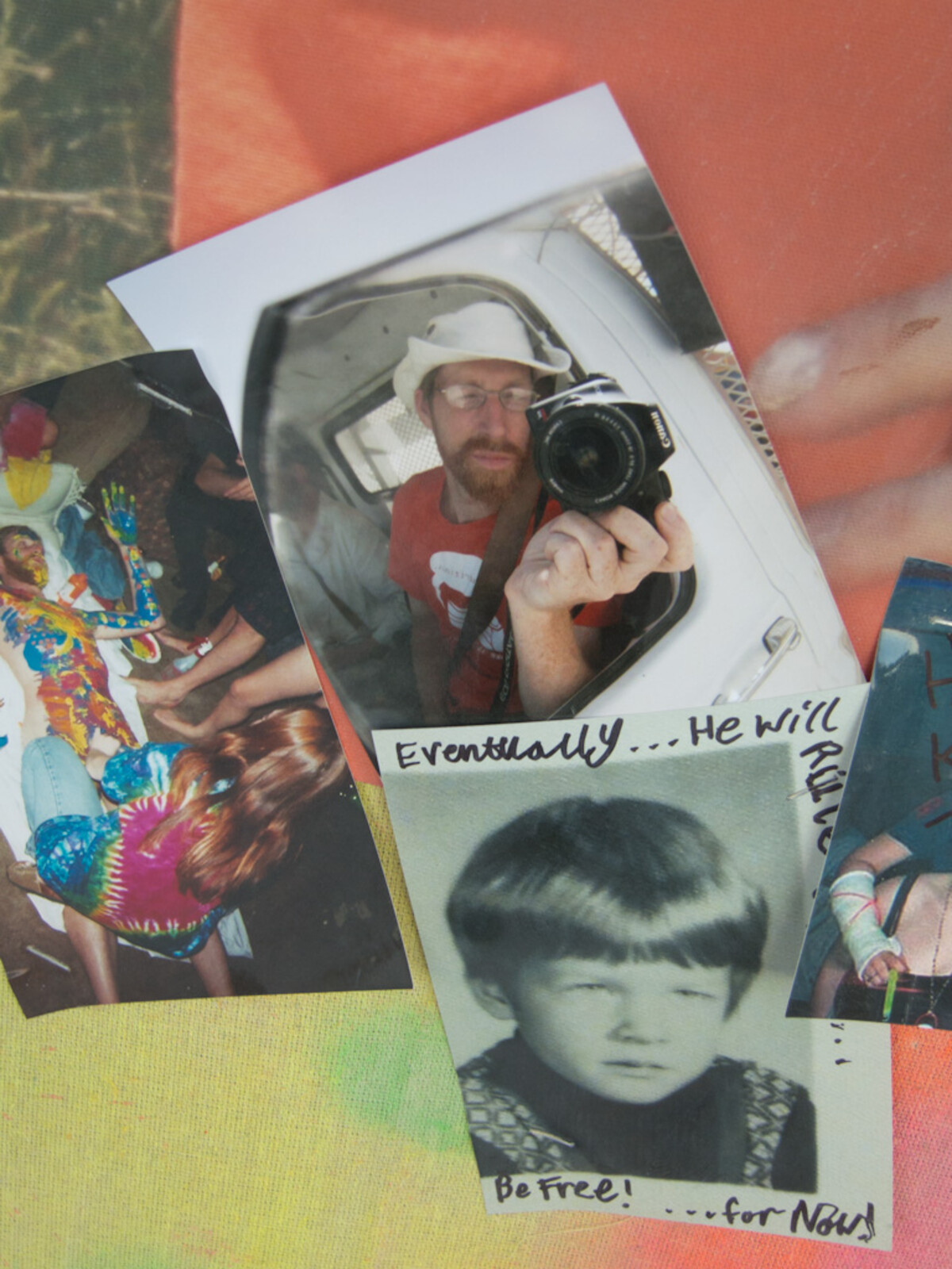 Close-up of photographs and a handwritten note pinned to the memorial temple: a bearded man in glasses and a white hat taking a mirror selfie with a Canon camera, a black-and-white childhood portrait of a boy, a colorful group photo, and the words 'Eventually… He will… Be Free! …for Now!'